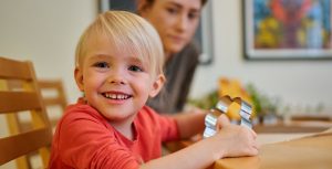 lapsi hymyilee piparkakkumuotti kädessään